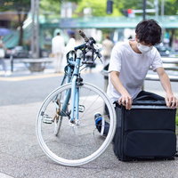 配達依頼の商品を専用の黒いバッグに入れて準備をするフードデリバリーの写真