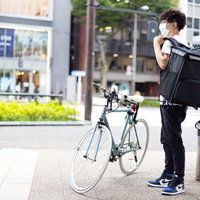 自転車で配達をはじめるフードデリバリーの男性の写真