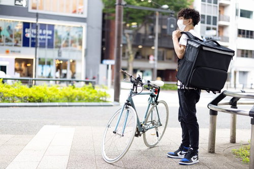 自転車で配達をはじめるフードデリバリーの男性