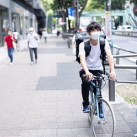 自転車で配達中の男性の写真
