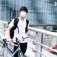 フードデリバリーで自転車配達する男性配達員の写真