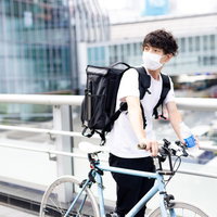 配達を終えて自転車を押して歩く男性配達員の写真