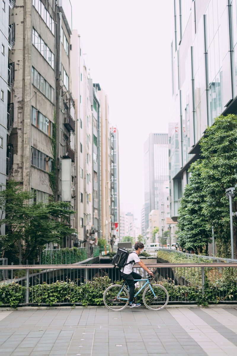 自転車に乗って配達地に向かうフードデリバリーのフリー素材