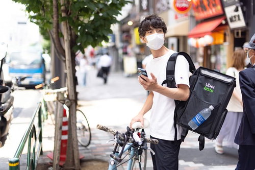 お昼時に見かけるフードデリバリーの配達員と自転車