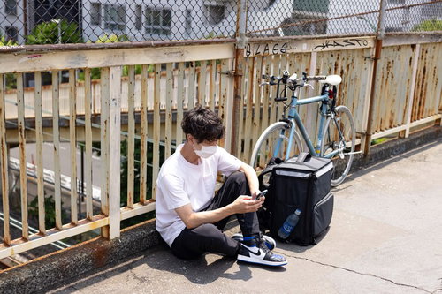 自転車での配達を終えて一息つく配達パートナー