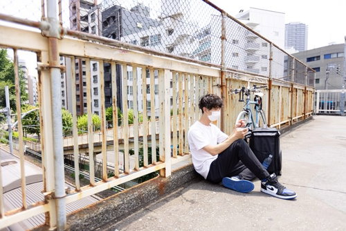 次の配達までの間、ベランダで休憩する配達員の男性