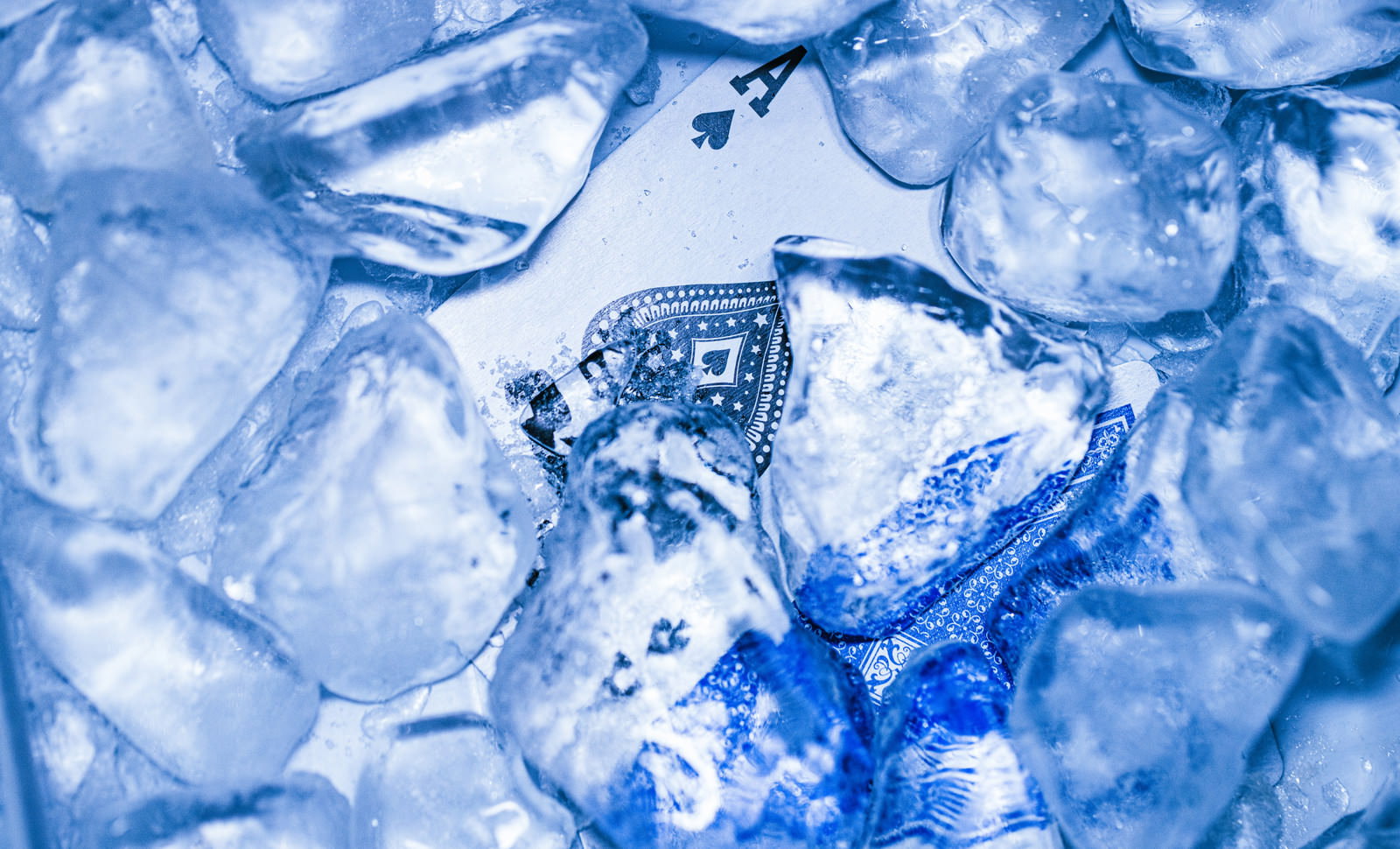 透明な氷の中に埋もれたスペードのエースのトランプカード