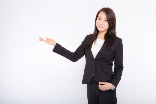 商品を案内する女性社員のポーズ、受付・営業シーン
