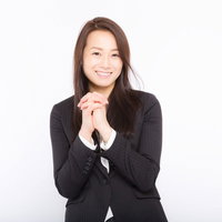 両手を合わせてお願いする黒いスーツの女性従業員の写真