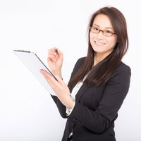 チェック漏れを笑顔で確認してくる眼鏡の女性社員の写真