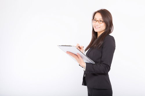 スーツ姿で棚卸し項目にチェックをつける女性