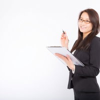 棚卸しをチェックするメモ帳とペンを持つ総務の女性社員の写真