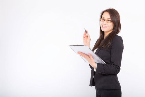 棚卸しをチェックするメモ帳とペンを持つ総務の女性社員