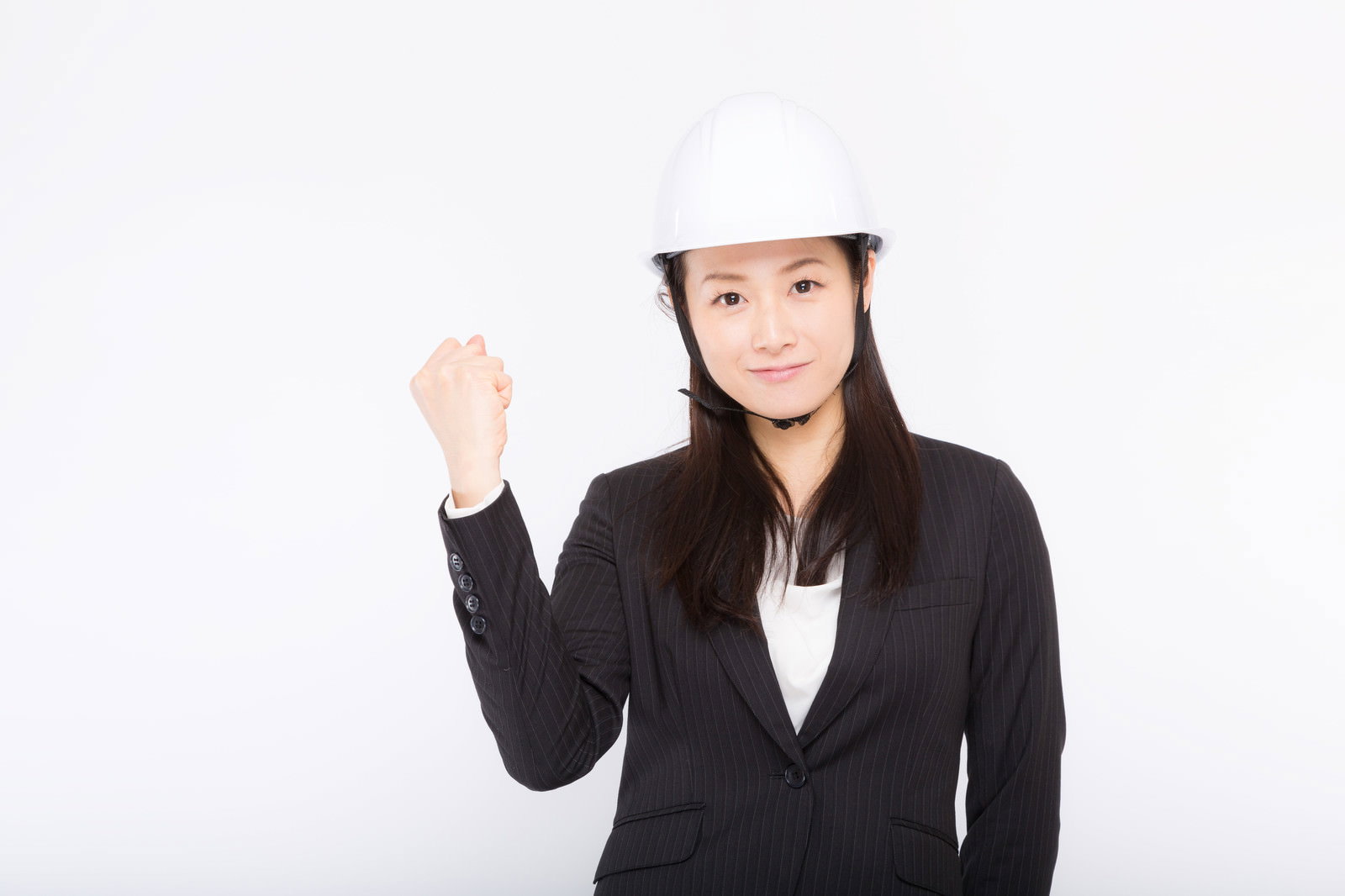 白いヘルメットをかぶり黒いスーツを着た女性が右手を上げて安全宣言をしている［モデル：土本寛子］