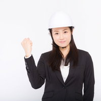 安全宣言するヘルメットをかぶった黒いスーツの女性の写真