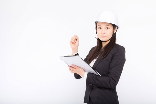 安全管理を怠らない女性社員がヘルメット着用でメモ確認