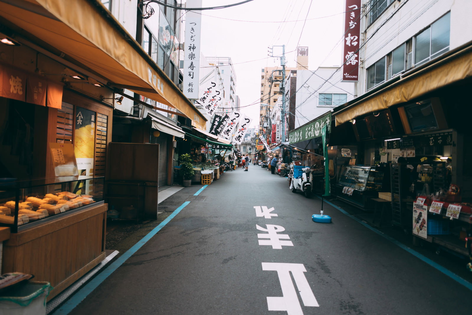 築地の商店街で両側に店舗が立ち並ぶ道路の風景