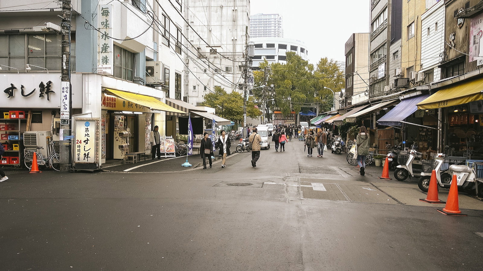 昭和レトロな商店が立ち並ぶ築地場外市場を歩く人々