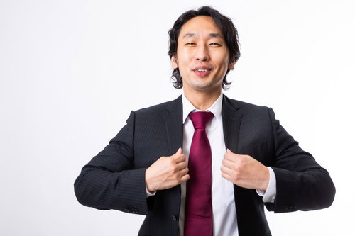 赤いネクタイで笑顔のエリアマネージャーがガッツポーズ