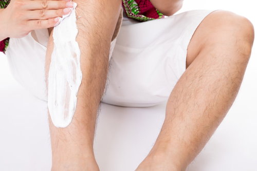 除毛クリームをすね毛部分に塗り塗りする男性