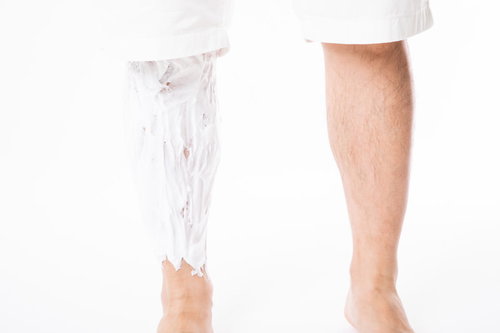 右足だけにシェーバークリームを塗る男性の脚