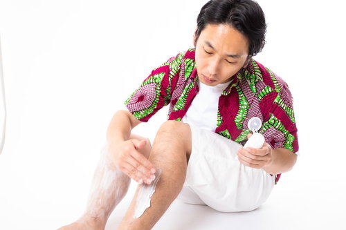 ムダ毛の処理後ボディクリームを塗る美容男子