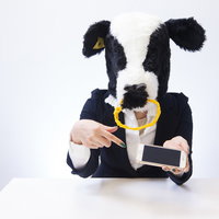 新作アプリへの辛辣なコメントを指差す牛のキャラクターの写真