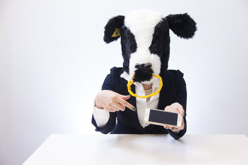 新作アプリへの辛辣なコメントを指差す牛のキャラクター