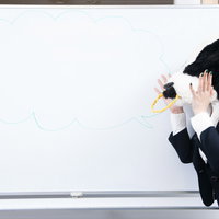 会議室のホワイトボードに吹き出しを書く牛上司の写真