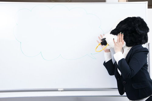 会議室のホワイトボードに吹き出しを書く牛上司