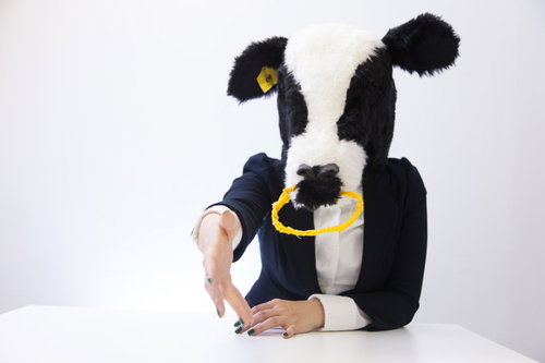 黄色いネックレスをつけた牛の被り物で握手を求めるパートナー