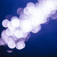 夜間照明がぼけて映る水面キラキラ、光の粒が浮かぶ夜景の写真