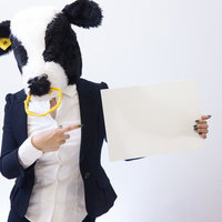重要なお知らせはこちらと指をさす怪しい牛人間の写真