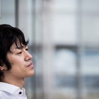 壁にもたれかかり下を向く男性、ストレスと疲労を感じるの写真