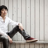 白シャツを着て座り込む男性のポートレートの写真