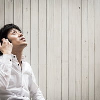 白いシャツを着て上を見上げる男性のポートレートの写真