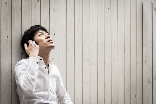 白いシャツを着て上を見上げる男性のポートレート