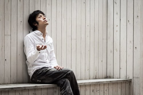 嫌なことがあった日はいつも雨の中でうなだれる男性