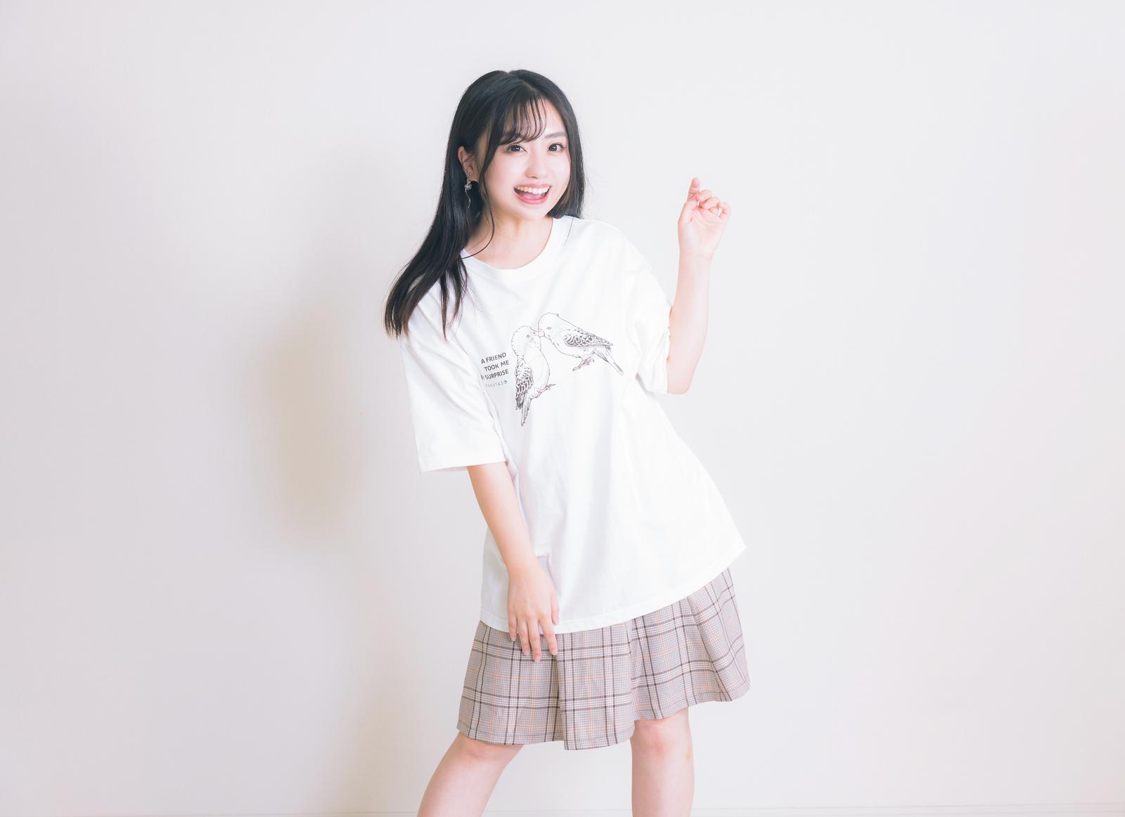 白いTシャツとチェックスカート姿で笑顔を見せる女性［モデル：河村友歌］