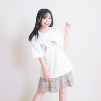 白いTシャツにスカートを合わせた笑顔の女性の写真