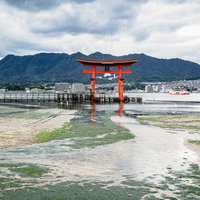 厳島神社の大鳥居と広島の山並みを望む風景の写真
