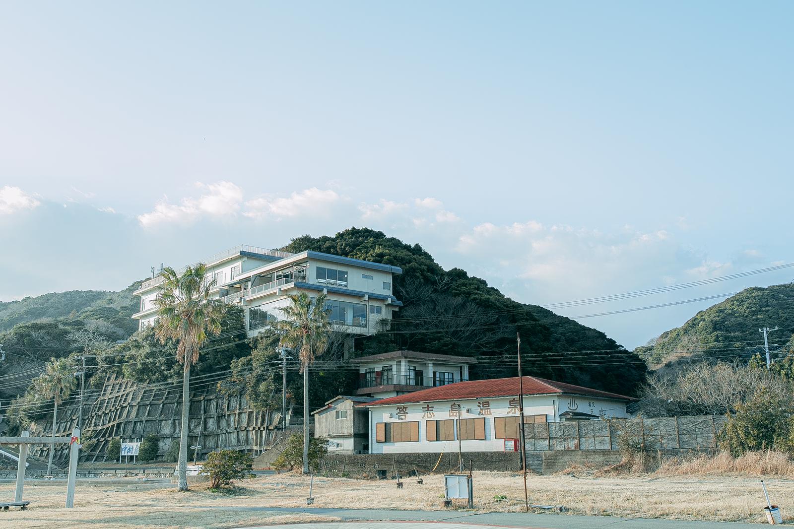 三重県答志島の和具にある温泉施設とヤシの木、山上の宿泊施設が見える風景