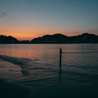 三重県答志島和具に打ち寄せる朝焼けの波打ち際の写真