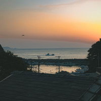 朝焼けに染まる三重県答志島の漁港と停泊する漁船の風景の写真