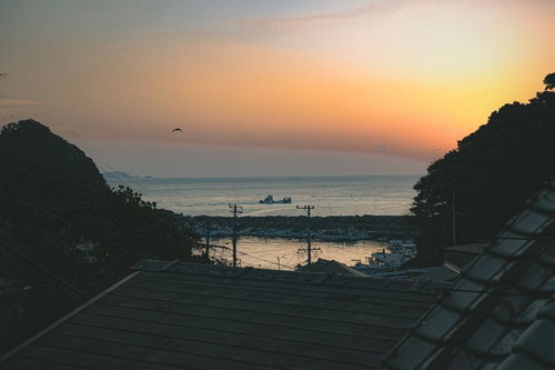朝焼けに染まる三重県答志島の漁港と停泊する漁船の風景
