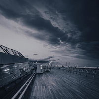 夜の横浜みなとみらいと歩道橋を歩く人影のライトアップ夜景の写真