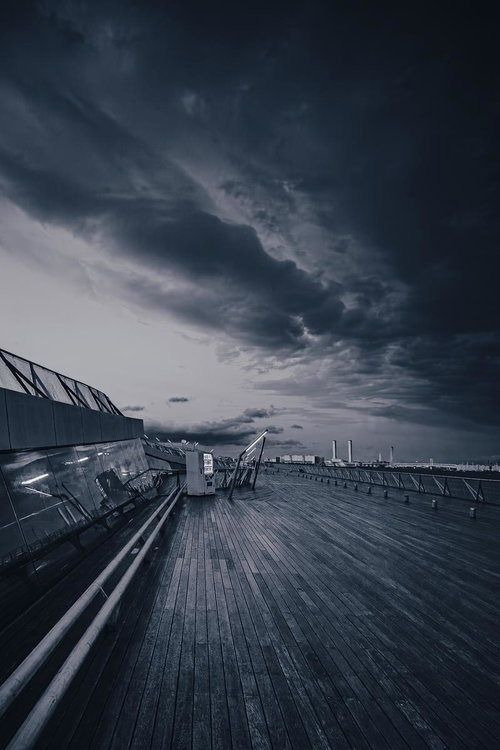 夜の横浜みなとみらいと歩道橋を歩く人影のライトアップ夜景