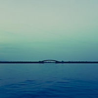 琵琶湖に浮かぶアーチ型の橋と穏やかな湖面の水平線の写真