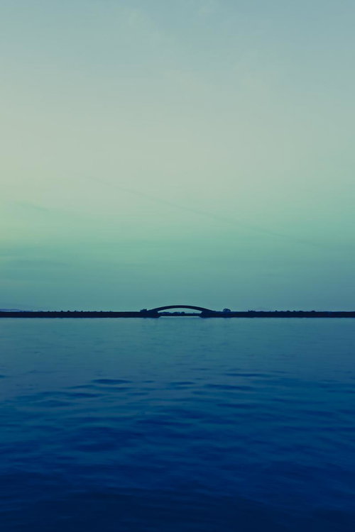琵琶湖に浮かぶアーチ型の橋と穏やかな湖面の水平線