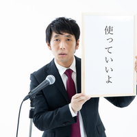 記者会見で「使っていいよ」をアピールするフリー素材の男性の写真